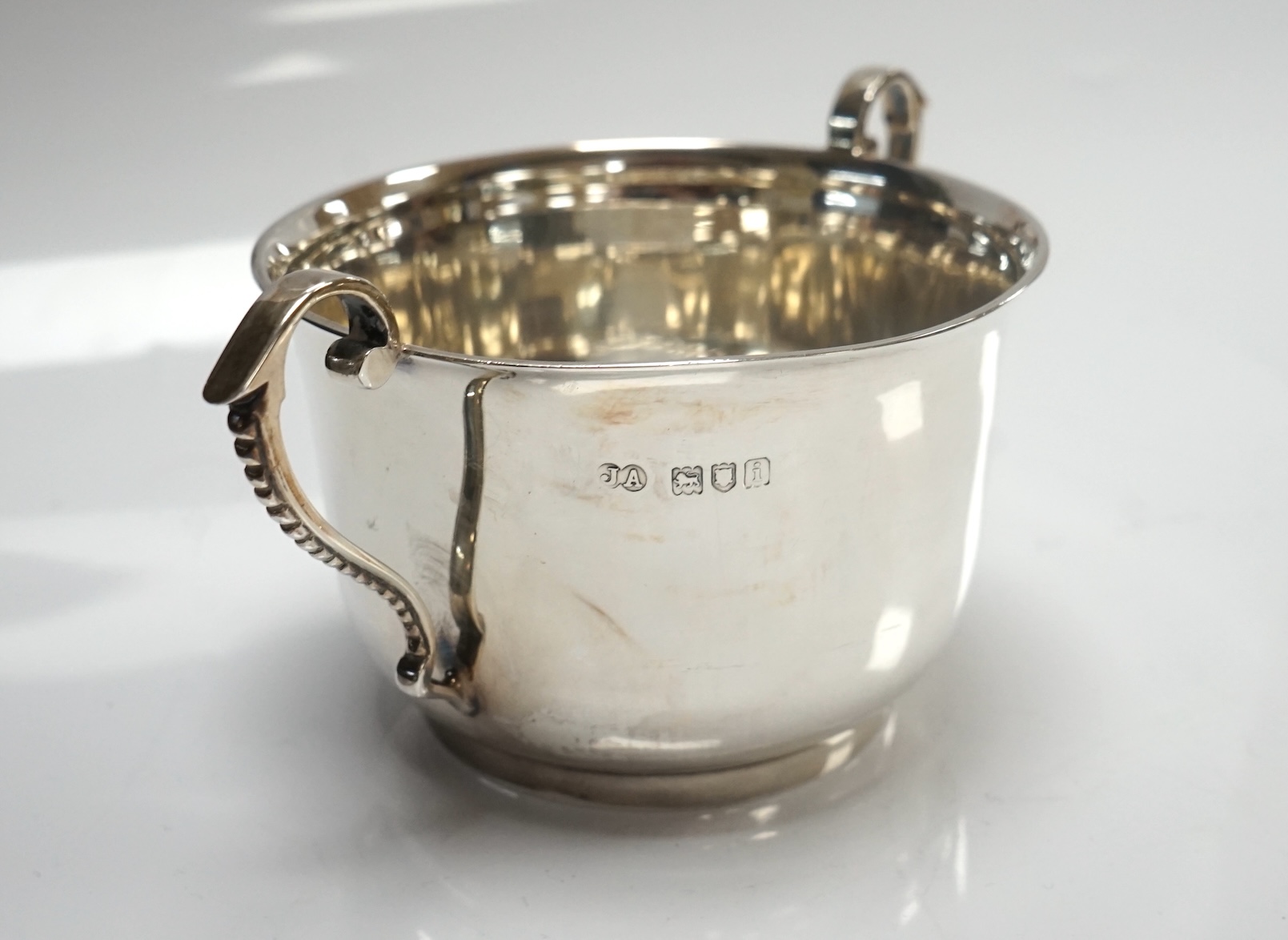 An Edwardian silver porringer, London, 1904, height 72mm, together with a pierced silver bonbon dish and an egg cup, 6.4oz. Condition - fair to good